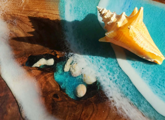 A seashell sits on a wave-like epoxy table.