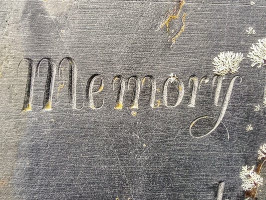 Engraved word memory on weathered stone surface