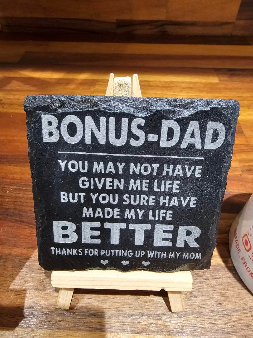 Engraved slate coaster reading 'Bonus Dad' showcasing heartfelt message, perfect for gifts.