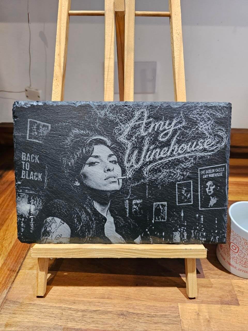 Amy Winehouse Back to Black Engraved Slate Plaque HandmadeUK on display with artistic design and black and white imagery.